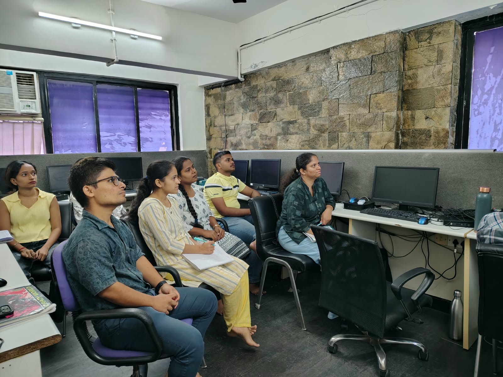 Participants seated beside desktop computers in the IT Accurate Thane classroom.